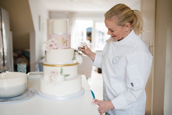 person decorating a wedding cake